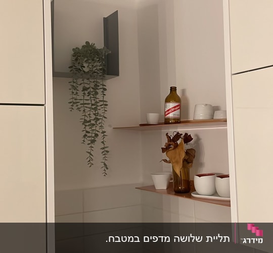 מדף עם בקבוק וכלים במטבח, מכונת קפה על השיש